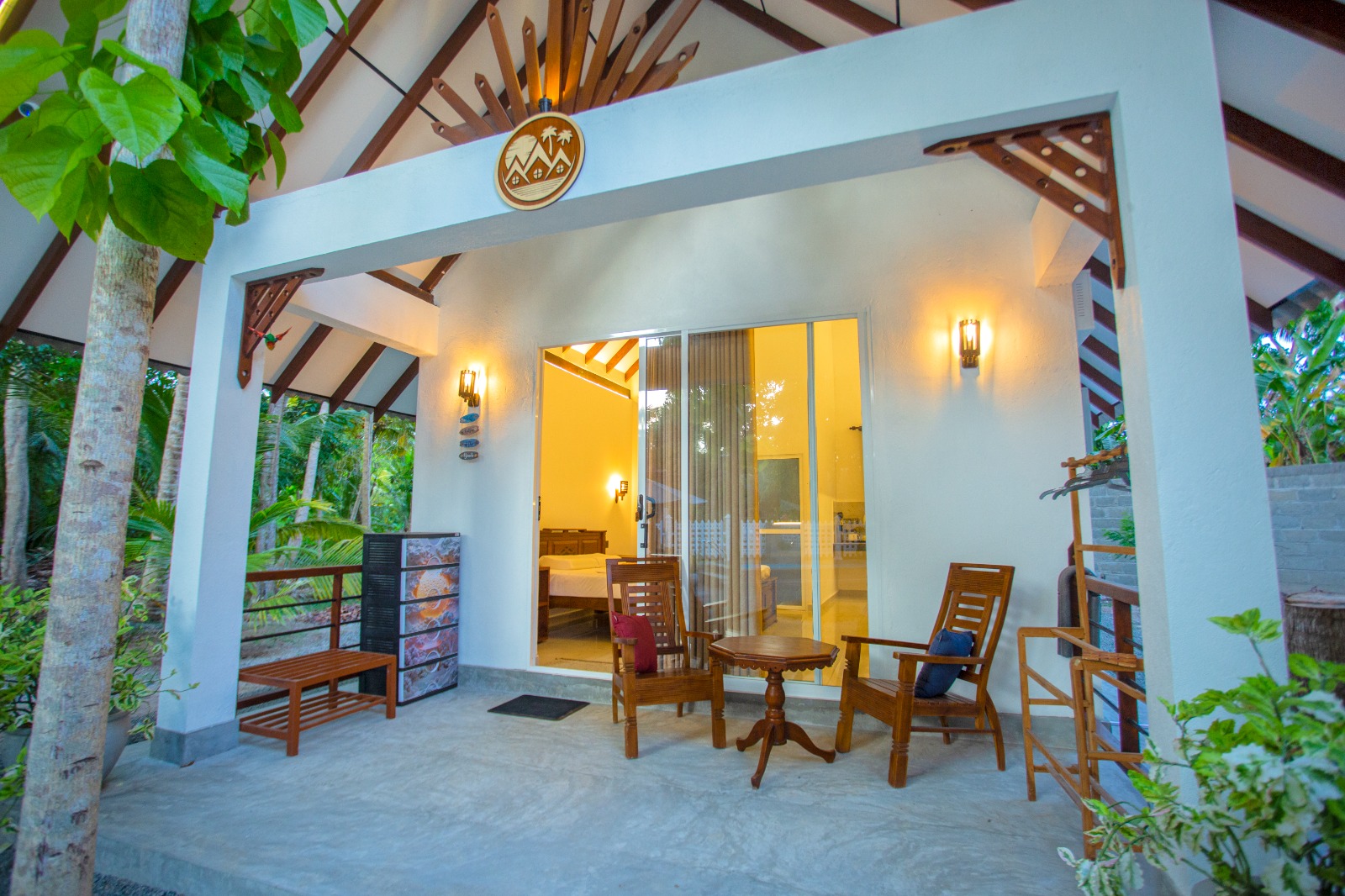 Covered villa veranda with wooden chairs and garden views