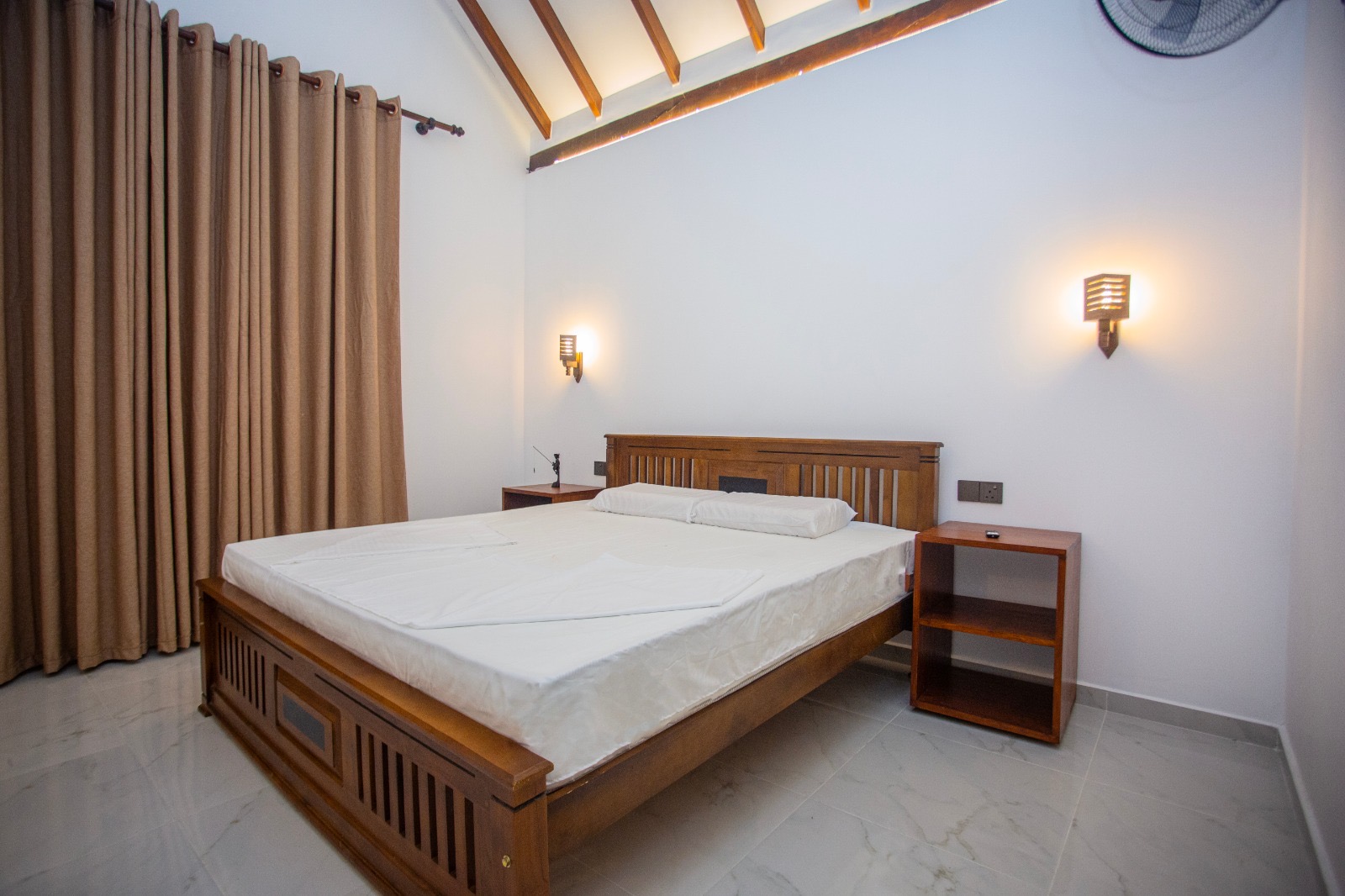 Spacious bedroom with a timber bed and high pitched ceiling